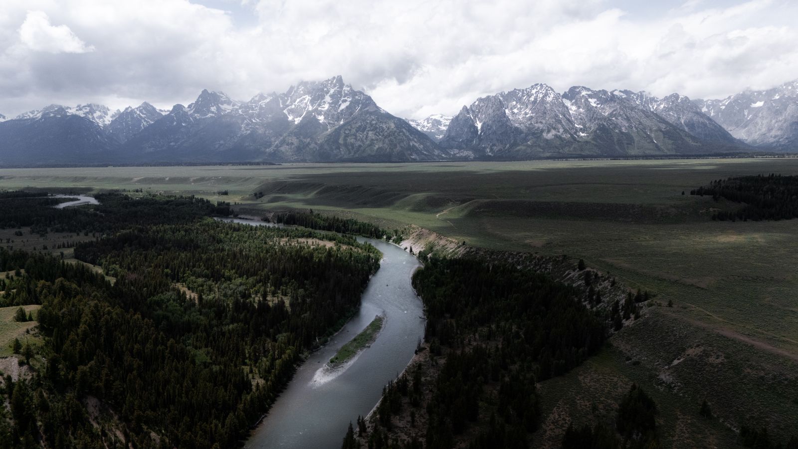 Aerial view of the Snake River winding below the Teton range