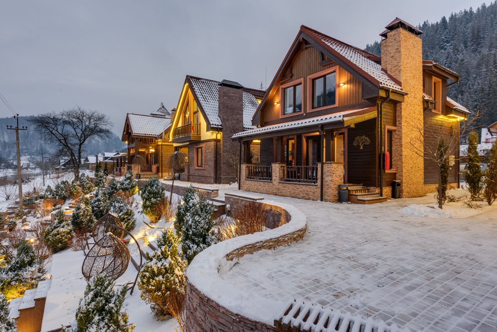 Lit chalets in the snow at dusk